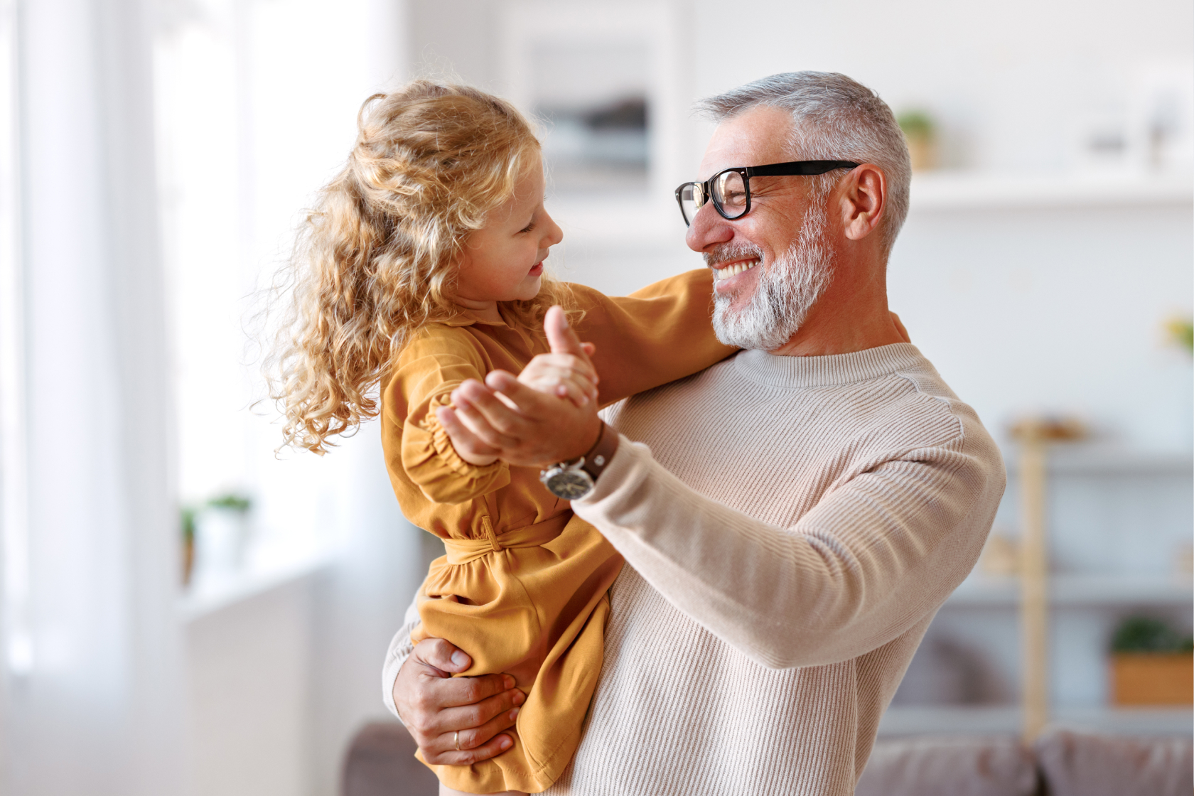 A little girl is picked up by her father as they dance around their home. Choosing a beneficiary is an essential part of estate planning.