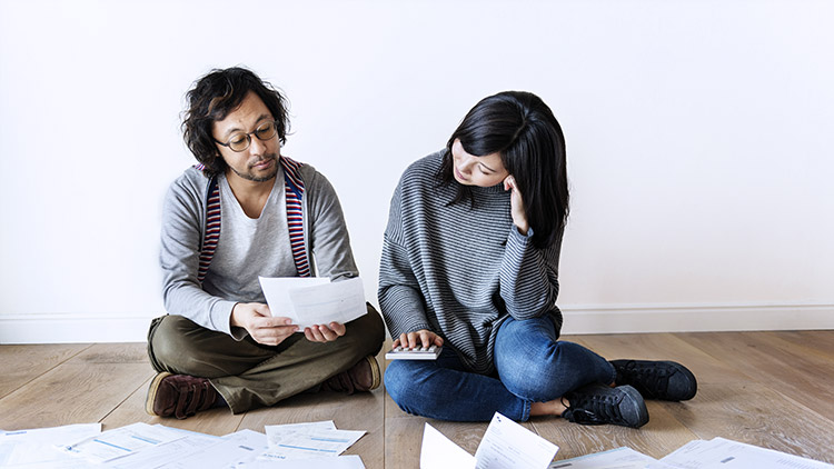 Man and woman look over bills and calculate costs