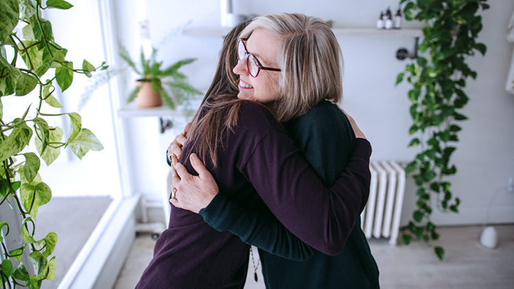 Older woman hugs adult daughter