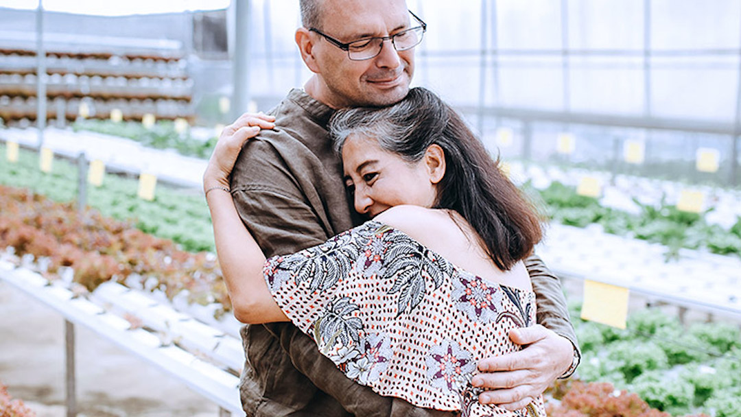 A middle-age man and woman embrace in a plant nursery. If you want to ensure that your estate goes to specific people, creating a last will and testament is the best way to fulfill those wishes.
