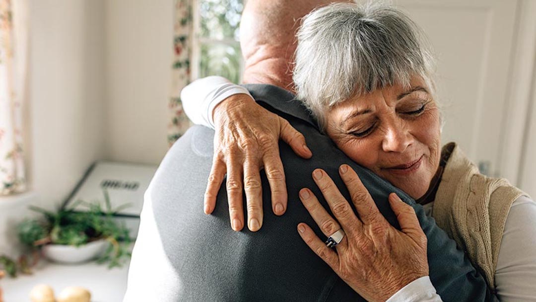 An elderly couple embraces after completing their California living trust documents. There are two kinds of living trusts: revocable and irrevocable.