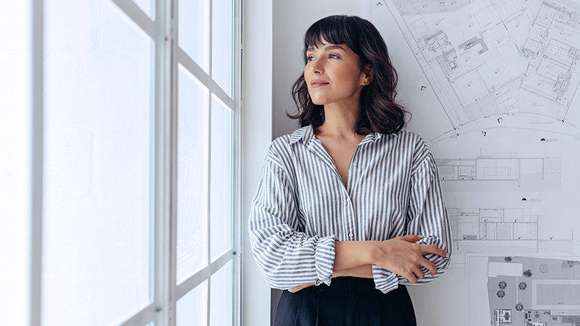 A woman leans against a wall in her office and looks out the window. Certain circumstances, such as state laws, the size of the estate, meticulous estate planning, and the type of assets involved, can influence whether a will has to go through probate.