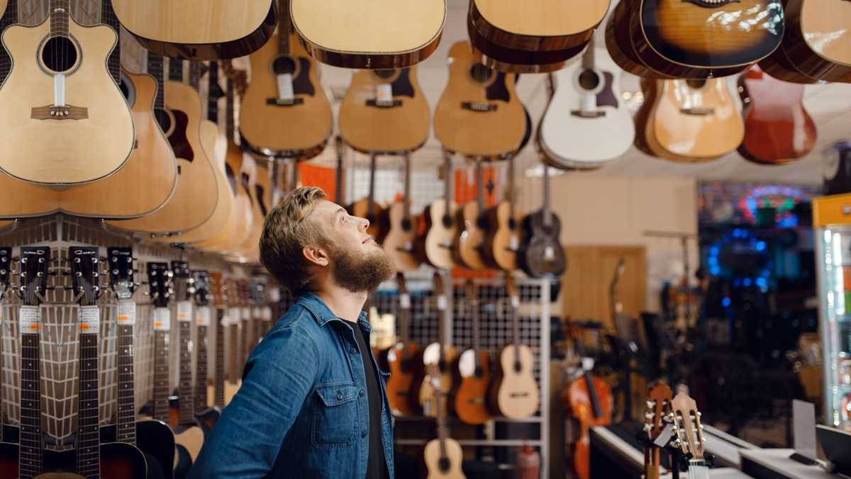 man in his guitar store thinking about net working capital formula for his business 