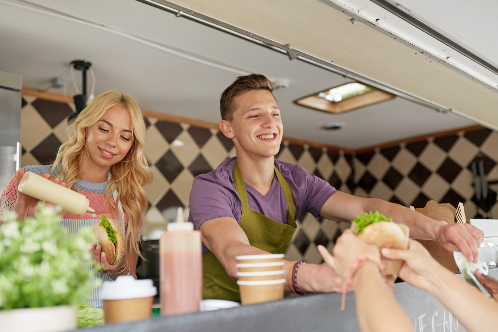 A woman and man in a food truck serve customers in Texas. If you are establishing a business in Texas, you will need to conduct a Texas business search with the Secretary of State to make sure your intended entity name isn't already being used.