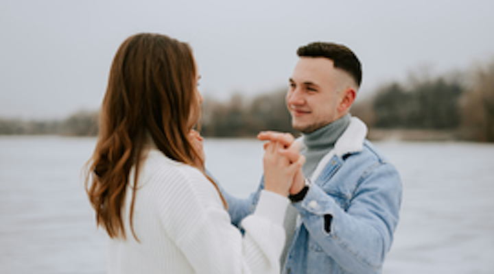 A woman and man face each other and interlock their fingers. If you work with an experienced attorney, you can get your Virginia premarital agreement executed properly. 
