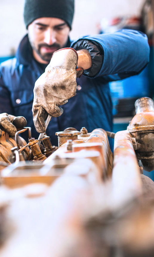 A mechanic works on a truck's engine.