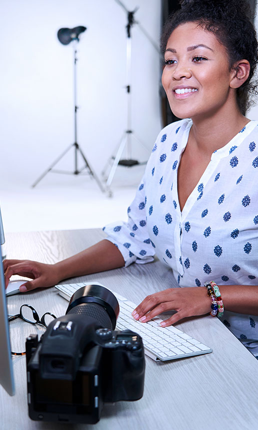 A photographer works on a computer in her studio.