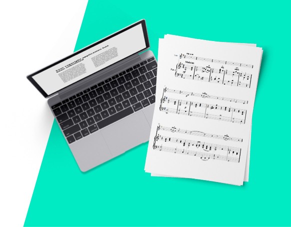 Sheet music sits next to a laptop.
