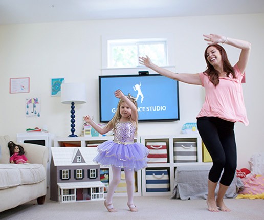 A mom and her daughter dancing in their living room.