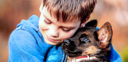 Young boy hugging his dog