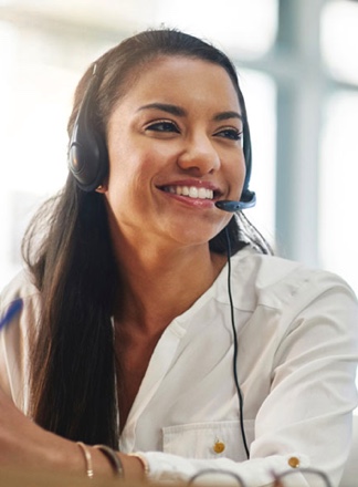 Woman in customer care on phone headset smiling.
