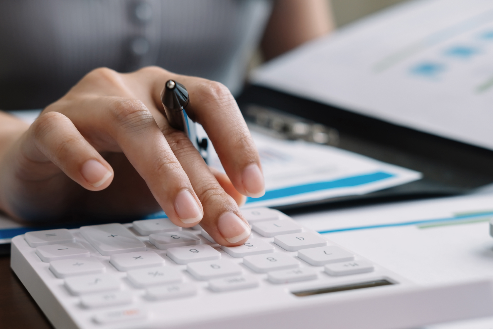 A person uses an adding machine to track sales and expenses. Accountants and bookkeepers can work together to keep your company’s financials on track. 