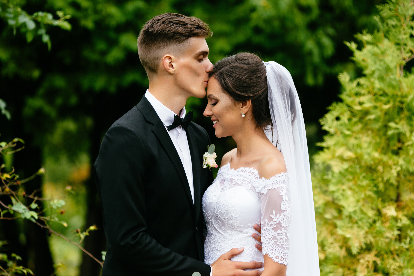 A man and woman in traditional dress attire share a kiss. A prenup can address a variety of topics, including financial responsibilities and spousal rights.