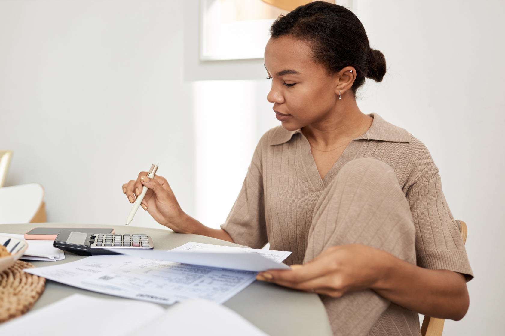 A woman looks over tax documents before filing online. Estimated tax payments are generally required of anyone who earns income that isn't automatically subjected to withholding taxes. 