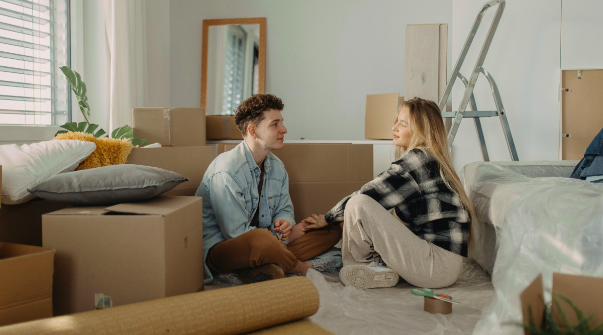 A newly married couple sit on the floor of their home in between unpacking boxes. As of this writing, there are nine community property states.