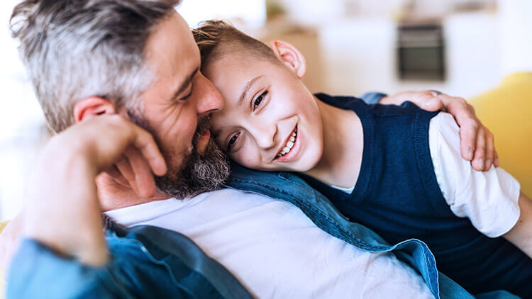 father hugging son on the sofa 