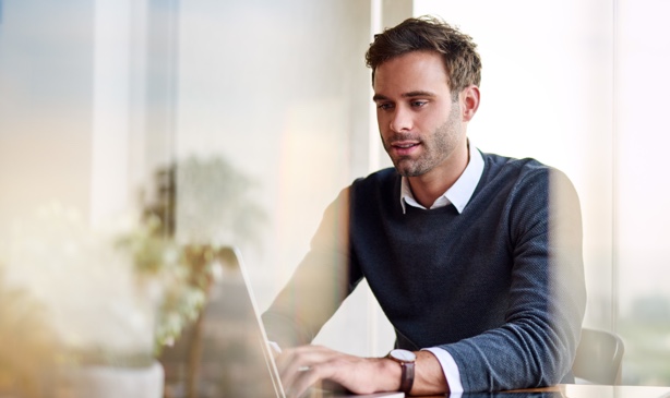 A business owner does research on his laptop.