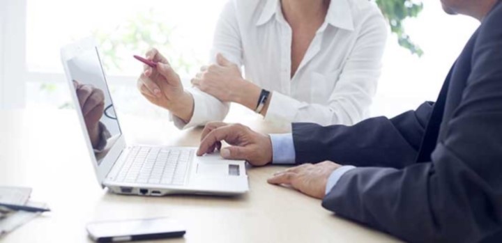 Businesswoman and businessman working together at a laptop