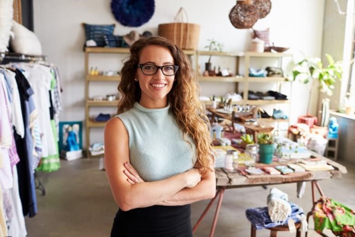 Woman with curly hair crossing arms and smiling in retail store