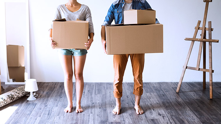 Man and woman holding moving boxes