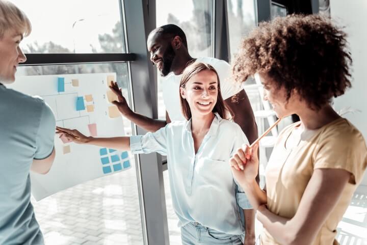 People looking at a blank flowchart on a window