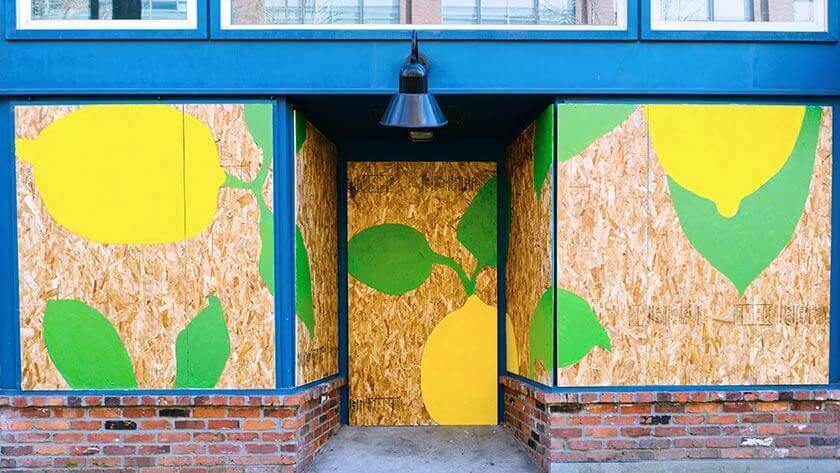 boarded-up-storefront-painted window with lemon painting 