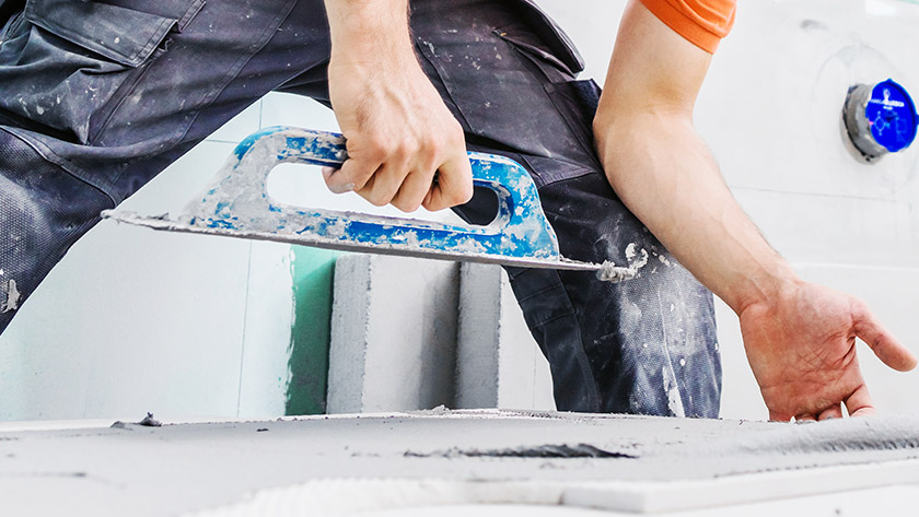 Construction worker laying tile