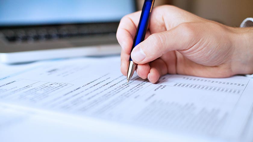 hand-signing-documents-blue-pen