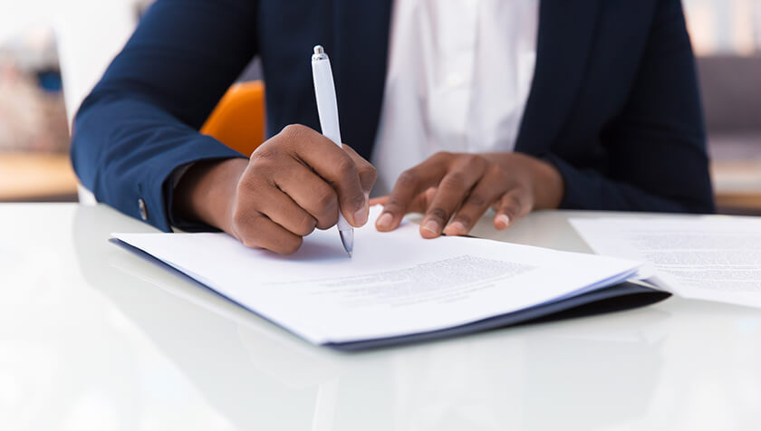 man signing paperwork with a white pen