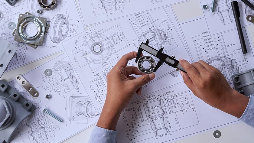 Man measuring part over diagrams