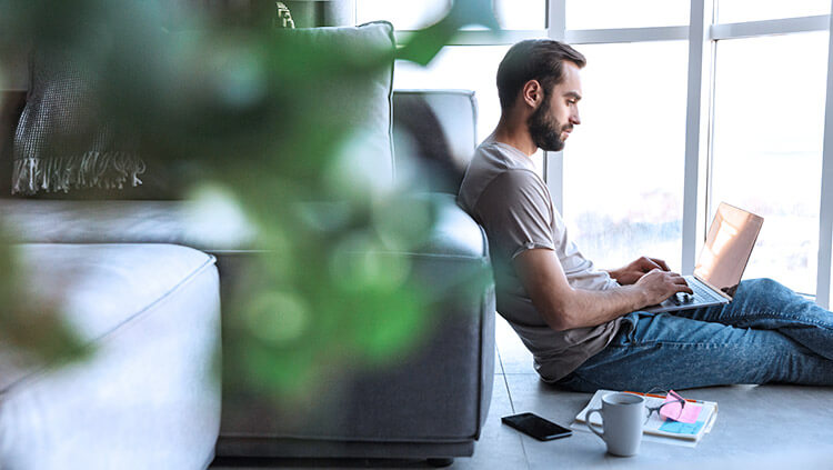 man-sitting-on-floor-typing