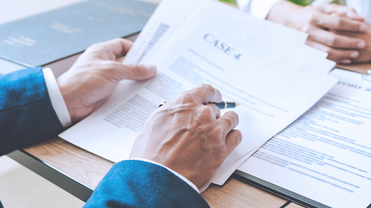 Man in suit reviews case paperwork with client