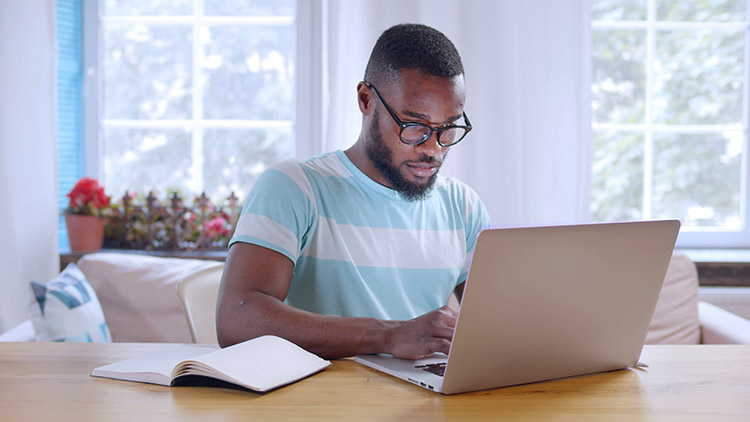 Man typing on laptop in home office