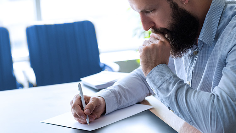 Man writing on paper in office