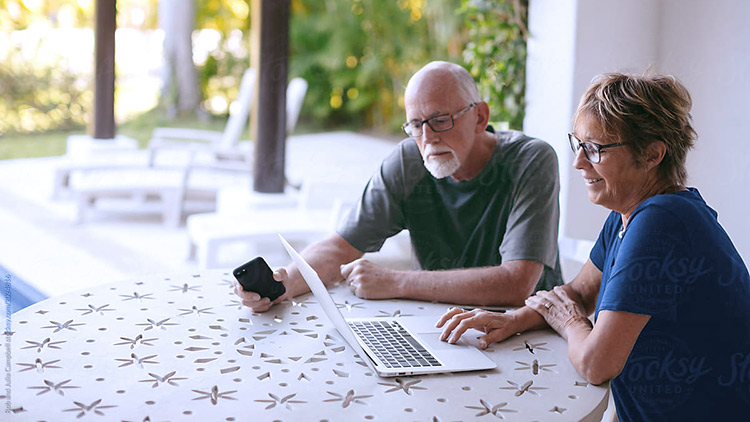 senior man and woman look at laptop