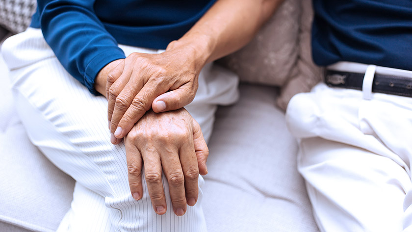 Senior hands resting on lap supporting