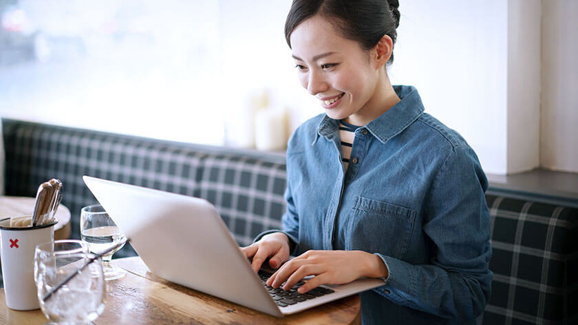woman smiling-typing-on-laptop