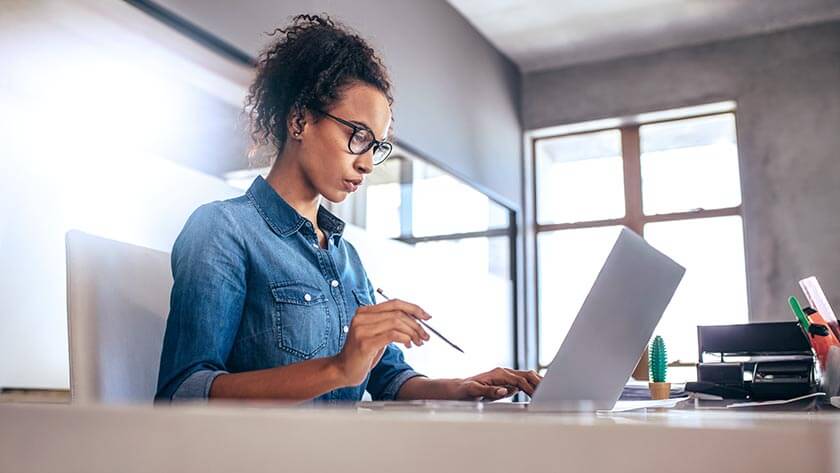 woman-concentrating-looking-at-laptop-in-office