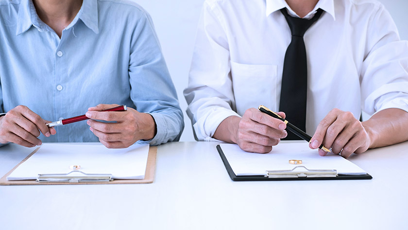 Woman and man side by side signing contracts
