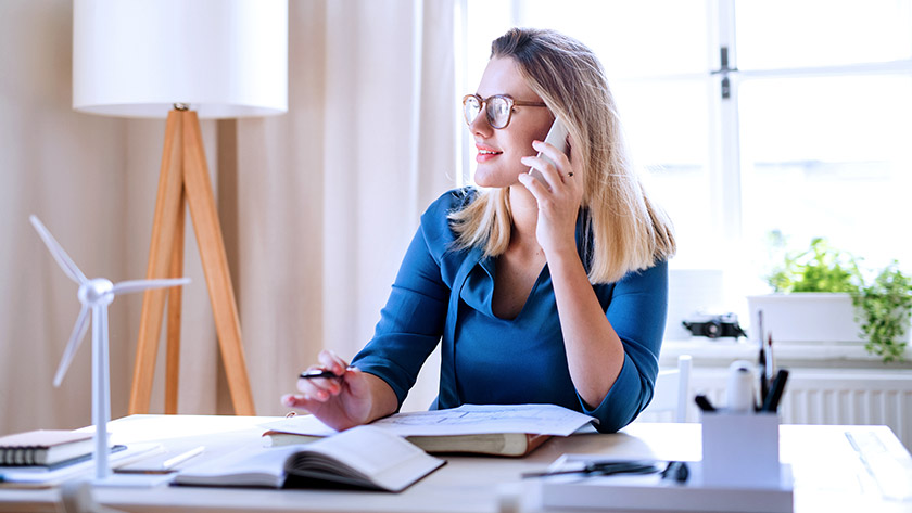 woman-on-mobile-phone-at-desk-looking 