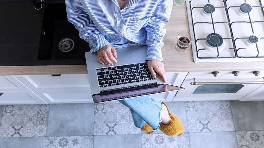 woman-sitting-on-counter-using-laptop