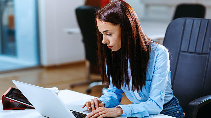 woman-typing-at-desk-on-laptop