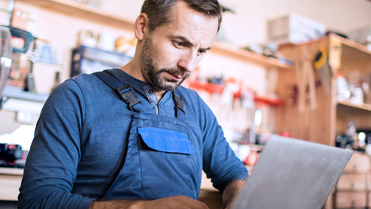 Woodworker man typing on laptop