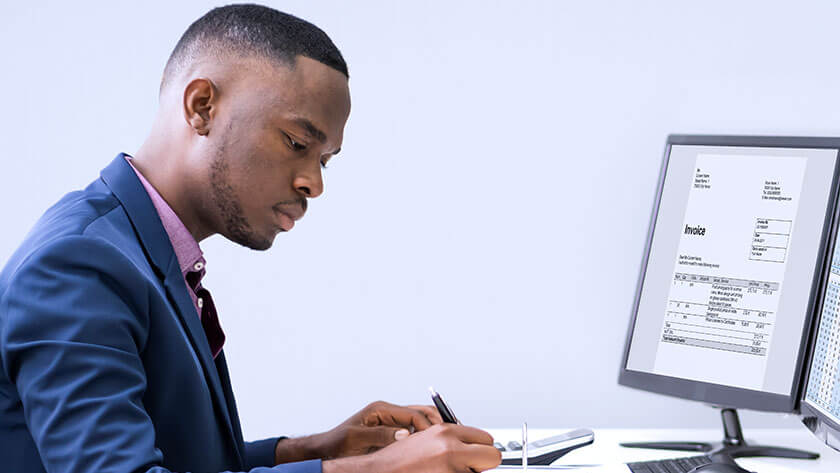 man in front of computer looking at his finances 