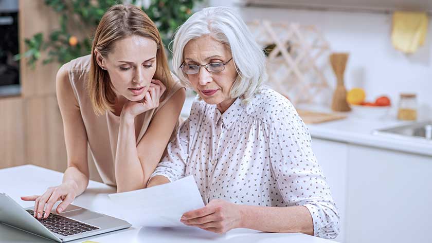 elderly woman and daughter looking over paperwork 