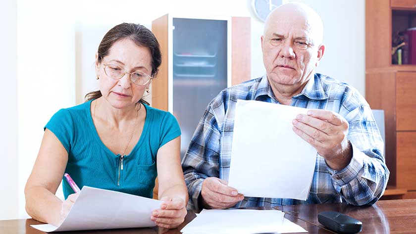 elderly man and woman looking through paperwork