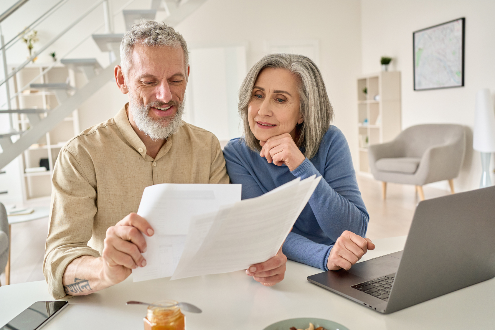 A man and woman seated at a counter look at a hard copy of their will. You might need a probate attorney to help you deal with a will or trust. Learn more by reading on.