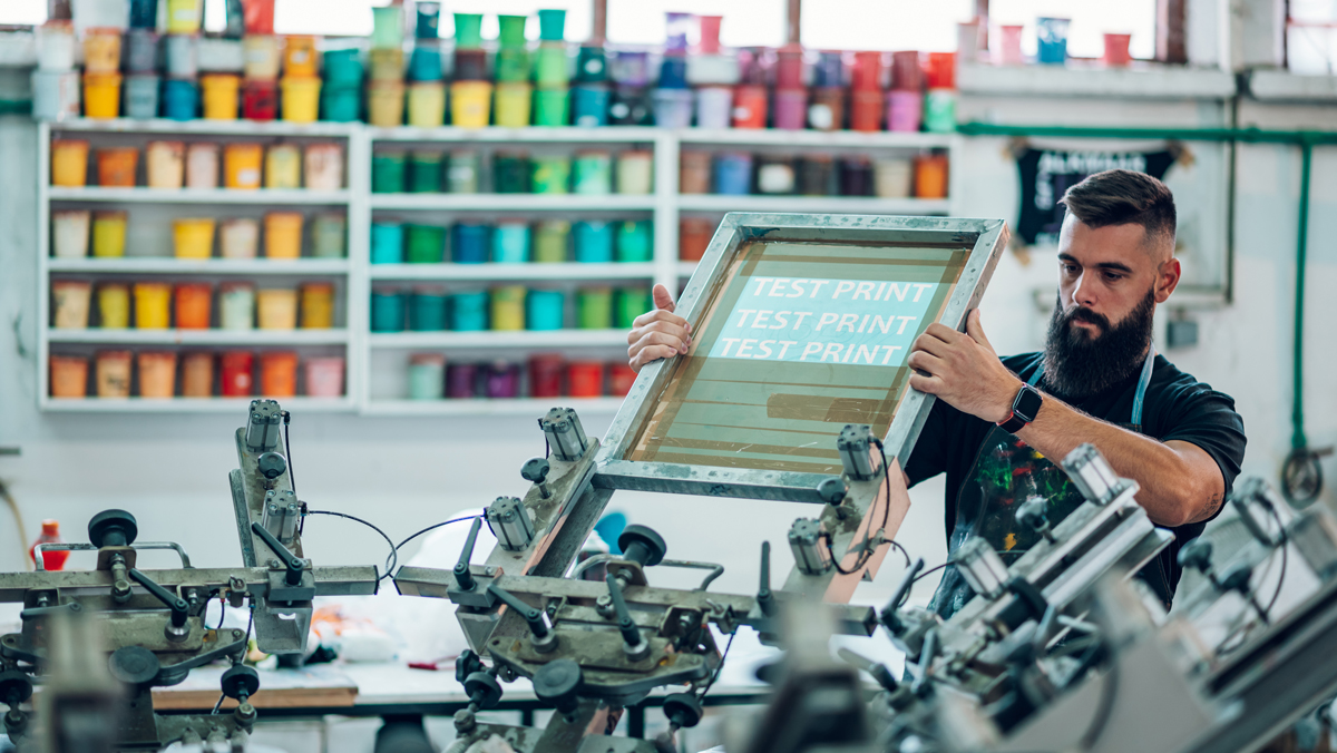 A man uses a screen-printing machine. This article may help you decide if double-declining balance is right for your business.