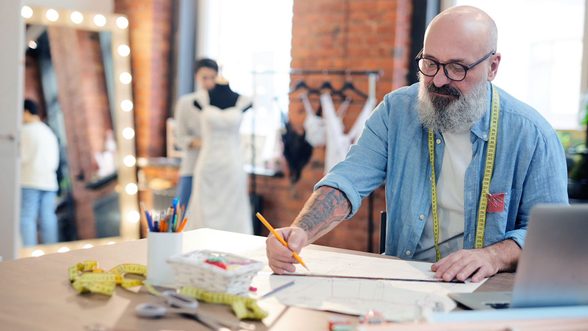 A clothing designer makes a sketch. His business could use employee benefit deductions.