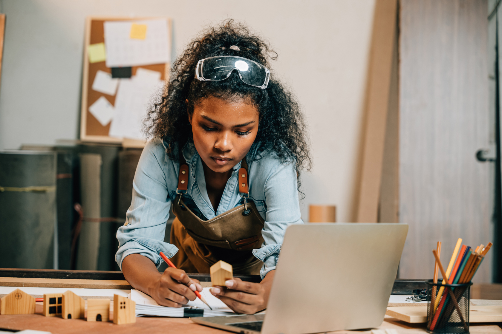 A small business owner takes measurements in her workshop for an architectural model.